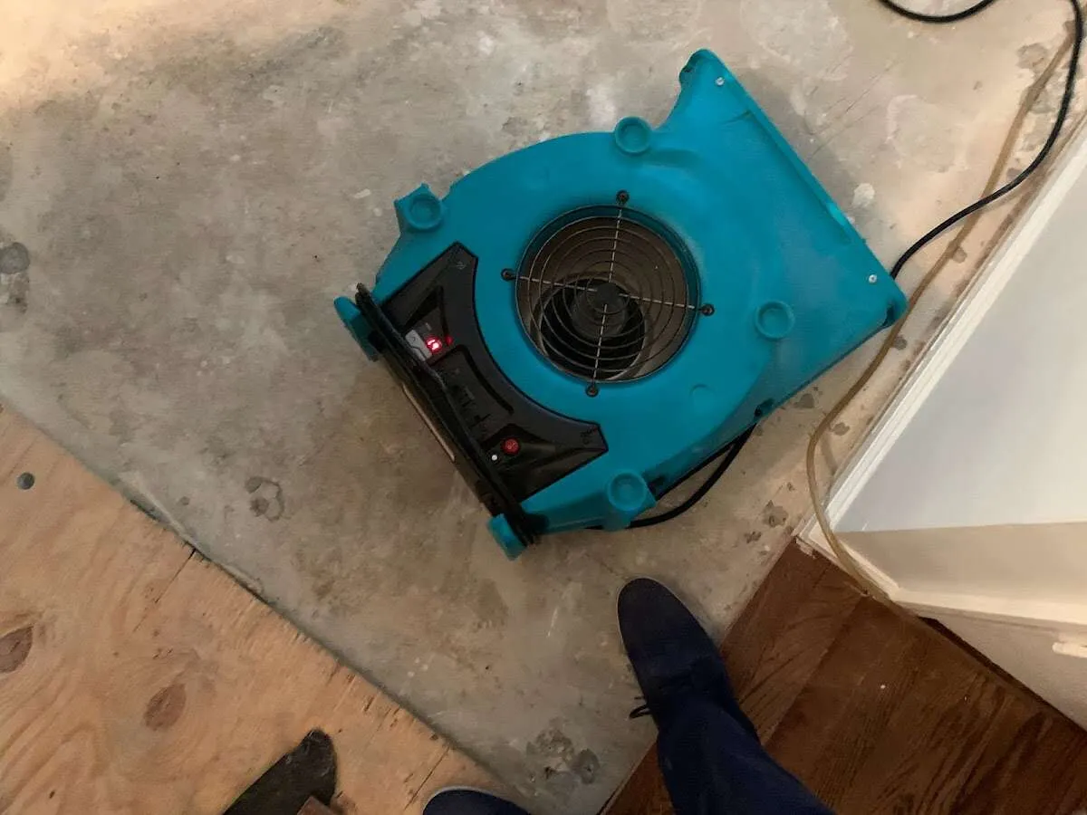 Air mover drying subfloor during Commercial Water Damage Restoration in Tiffin
